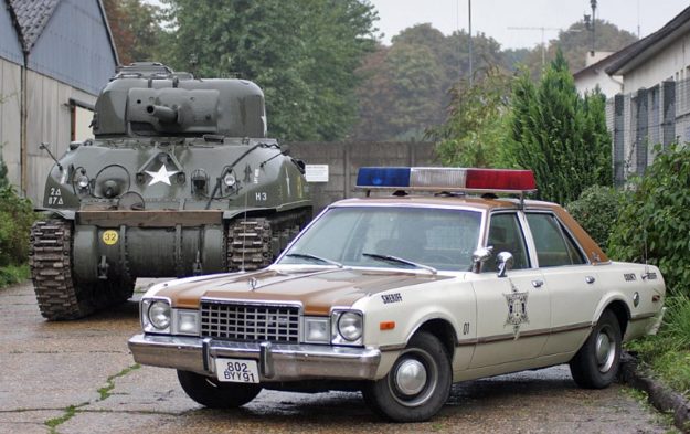 Juste après l’entrée la Plymouth du shérif et le Sherman.